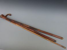 Three Oriental walking canes including carved pokerwork examples and a cane with a silver collar