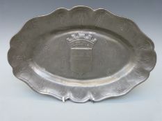 A pewter dish with crest detail and English touch marks to base