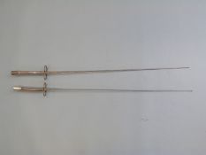 A pair of fencing epees with figure of eight guards and wire handles,