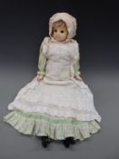 A wax headed doll with weighted blue eyes, soft body and composition lower limbs,