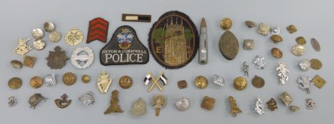 A collection of military buttons and badges to include the Huntingdonshire Regiment and ARP buttons