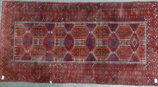A Turkoman rug with central panel of guls on a wine ground (76 x 90cm)