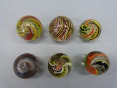 Six very large glass marbles, all with multicoloured latticino twists,