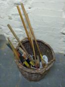 A quantity of croquet mallets and accessories in a wicker log basket