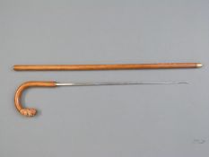 A wooden sword stick, the curved handle in the form of a dog's head,