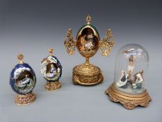 Three House of Faberge religious themed eggs and a model of the crucifixion under a glass dome