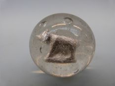 A large glass marble with sulphide cameo in the form of a dog or bear,