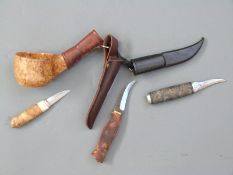 Three Finnish hunting knives each with wooden handles and leather sheaths,
