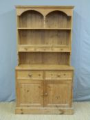 A pine dresser with an arrangement of cupboards,