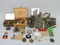 A quantity of military cloth and metal badges of rank, belt buckles,
