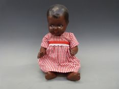 A jointed doll with composition body and gingham dress, marked 'B British',