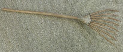 A wooden rake formed from tapered wood bound with leather, possibly tribal,