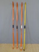 Four various fibreglass archery bows three in orange and one yellow.