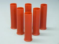 Six 4 bore plastic shotgun cartridge cases.