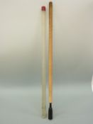 A woollen gun cleaning rod in protective tube, 103cm long.