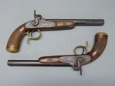 A pair of percussion hammer action pistols with chequered grip, ornate engraving to the locks,