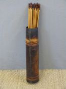 Thirty-six wooden barbed metal tipped wooden hunting arrows in leather quiver.