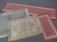 Five Persian style wool rugs, three red and two green, four rectangular, one a runner,