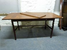 A retro Danish style extendable dining room table with shaped legs united by curved stretchers (H71