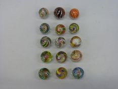 Fifteen large glass marbles, all with multicoloured latticino twists,