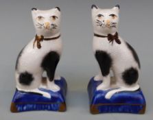 A pair of 20th century Staffordshire cats on blue square bases,