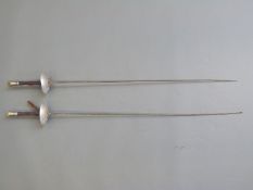 A pair of fencing epees with saucer guards,