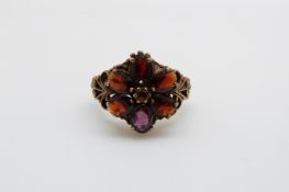 A 9ct gold ring set with garnets in a large flower cluster, 4.