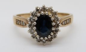 An 9ct gold ring set with a sapphire surrounded by diamonds (size O)