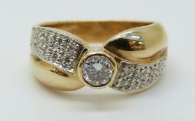 A 14ct gold ring set with a diamond with further diamonds to the shoulders,