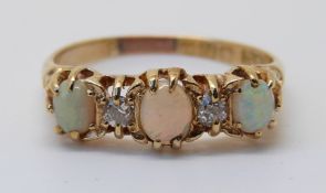 An 18ct gold ring set with three opal cabochons and two old cut diamonds (size S)