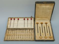 A cased set of six French silver gilt and ivory cocktail stirrers and cased set of twelve white