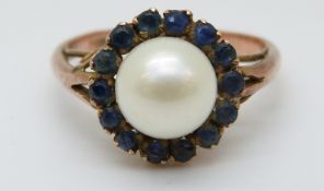 A 9ct gold ring set with a pearl surrounded by sapphires (size K)