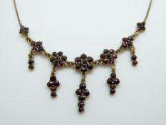 A Victorian necklace set with bohemian cut garnets.
