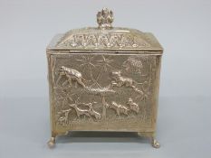 An Indian/Burmese white metal tea caddy with relief decoration of wild animals including elephants,