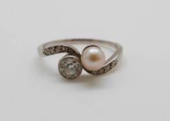 A platinum ring set with an old cut diamond measuring approximately 0.48ct and a pearl, 3.