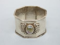 A Sybil Dunlop hallmarked silver Arts and Crafts hammered silver octagonal napkin ring with applied