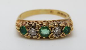 An 18ct gold ring set with diamonds and emeralds (size M)