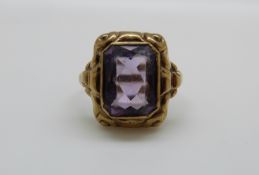 A yellow metal ring marked 333 set with an emerald cut amethyst, 3.