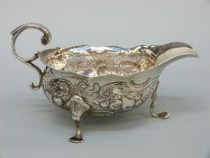 A Georgian hallmarked silver sauce boat with embossed decoration,