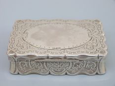 A Victorian hallmarked silver table top snuff box with shaped lid and engraved decoration,