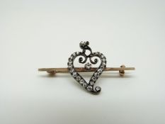 A late Victorian/ Edwardian brooch set with old mine cut diamonds in the form of a heart,