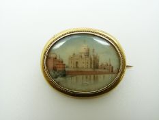 A 19thC yellow metal brooch set with an Indian miniature depicting the Taj Mahal, 3.5 x 2.