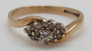 A 9ct gold ring set with diamonds in a cluster with a cross over design (size J)
