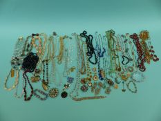 A collection of costume jewellery to include beaded necklaces, brooches, rabbit foot, jet beads,