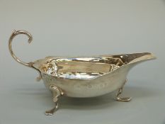 A George V hallmarked silver sauce boat raised on three feet, London 1921 maker Reid & Sons Ltd,