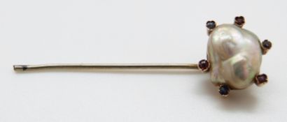 A stick pin set with a baroque pearl approximately 1.5 x 1.
