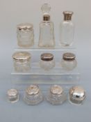 Eight hallmarked silver-topped dressing table jars and two silver-mounted scent bottles