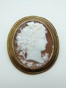 A Victorian brooch set with a large cameo within a rope twist and textured border, 4.