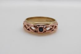 A 9ct gold Clogau ring set with a sapphire in a pierced setting (size O/P)