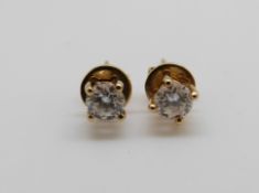 A pair of 18ct gold earrings each set with a round brilliant cut diamond of approximately 0.